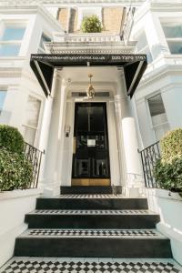 a white house with stairs leading to the door at Merit Kensington Hotel in London