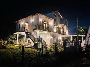 アヌラーダプラにあるTheon Resortの夜間照明付きの大きな白い家