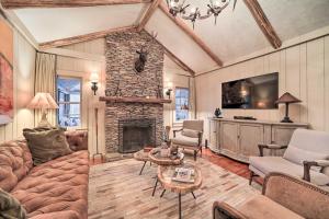 a living room with a couch and a stone fireplace at Mirror Lake Cabin about 1 Mi to Dtwn Highlands! in Highlands