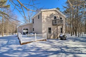 a white house with a balcony in the snow at Deck, Pool, Trails Access Pocono Family Home! in Albrightsville