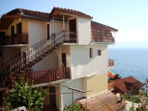 a building with stairs and balconies next to the ocean at Sonce Guest House in Ohrid +34 photos