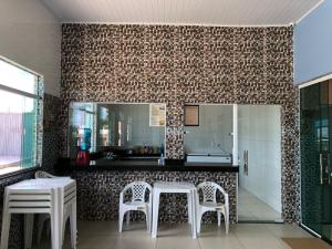 cocina con mesa, 2 sillas y espejo en Pousada Portal da Villa, en Vitória da Conquista