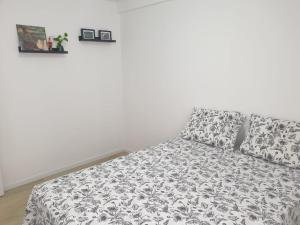 a bed with a black and white comforter and two pillows at QUARTO privado na Orla de Petrolina in Petrolina