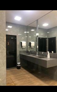 un bagno con due lavandini e un grande specchio di Hotel Cavalinho Branco - 106 ad Águas de Lindóia