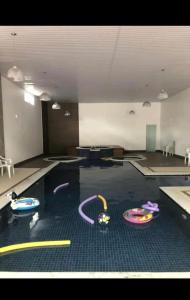 a room with a swimming pool with toys on the floor at HOTEL CAVALINHO BRANCO in Águas de Lindóia