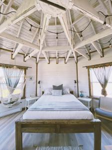 a bedroom with a large bed and two windows at Auberge Paradis Bleu in Fatima