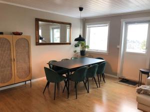 a dining room with a table and chairs and a mirror at Sentralt rekkehus med solrik veranda! in Arendal