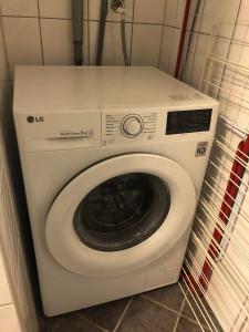 uma máquina de lavar roupa branca num canto de um quarto em Sentralt rekkehus med solrik veranda! em Arendal