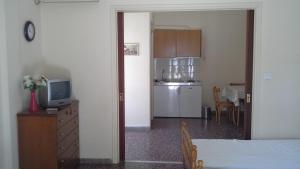 a living room with a television and a kitchen at Stamatiou Dimitris in Methana +17 photos