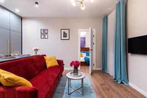 a living room with a red couch and a table at Lovely apartment Traku str. in Vilnius