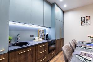 a kitchen with a sink and wooden cabinets at Lovely apartment Traku str. in Vilnius +11 photos