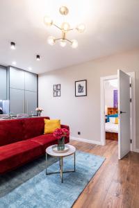 a living room with a red couch and a table at Lovely apartment Traku str. in Vilnius