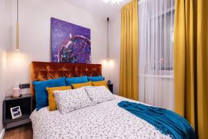 a bedroom with a bed with blue and yellow curtains at Lovely apartment Traku str. in Vilnius