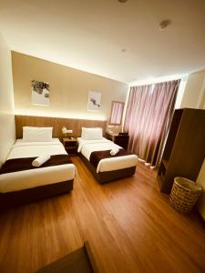 Un pat sau paturi într-o cameră la LABUAN JATI HOTEL