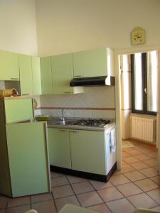 - une cuisine avec des placards verts et une cuisinière four supérieur dans l'établissement Villa Liberty, à La Maddalena