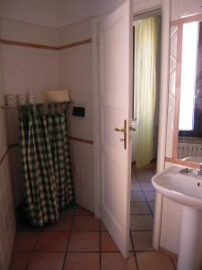 La salle de bains est pourvue d'un lavabo et d'un rideau de douche. dans l'établissement Villa Liberty, à La Maddalena