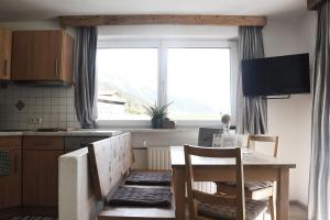 eine Küche mit einem Tisch und Stühlen sowie einem großen Fenster in der Unterkunft Familie Pfefferkorn in Steeg