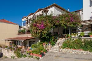 a house with flowers on the side of it at pension holidays studios in Vasiliki