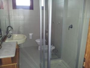 y baño con ducha, aseo y lavamanos. en Villa Francesca, en Flumini di Quartu