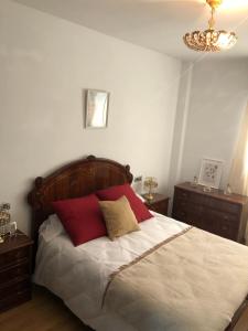 a bedroom with a bed with red pillows on it at Apartamento Maracena Centro in Maracena