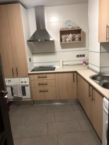 una cucina con mobili in legno e un forno a piano cottura di Apartamento Maracena Centro a Maracena