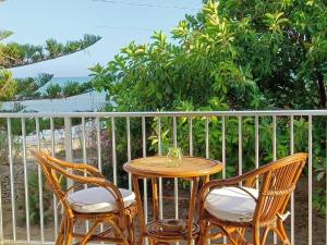 Una mesa y dos sillas en un balcón. en Casa Panarea - Villetta indipendente sul mare, en Marina di Modica