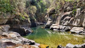 a river in a rocky canyon with green water at Ecopousada Toca do Guará in Alto Paraíso de Goiás