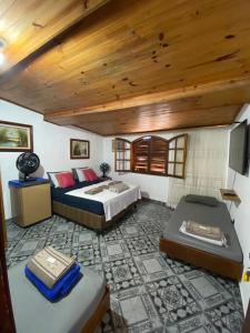 um quarto com 2 camas e um tecto de madeira em Casa Vila Mar - Inn Prainha em Arraial do Cabo