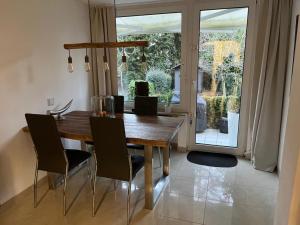 Un comedor con mesa y sillas de madera. en Casa Arturo Düsseldorf, en Düsseldorf 33 fotos más