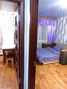 a bedroom with a bed and a table and a window at Уютные апартаменты c кондиционером на Уманчанке in Umanʼ