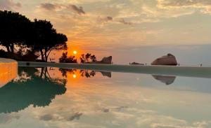 a reflection of the sunset in a swimming pool at Eight Dimensions Capari Suites Elafonisos in Elafonisos