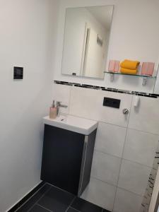 a white bathroom with a sink and a mirror at Ferienwohnung Annashome in Maxhütte-Haidhof