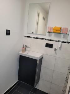 Baño blanco con lavabo y espejo en Ferienwohnung Annashome, en Maxhütte-Haidhof