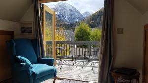 a room with a chair and a balcony with a mountain view at Sunnyside East End in Telluride