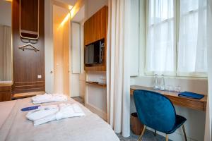 a hotel room with a bed and a blue chair at Blue Liberdade Hotel in Lisbon