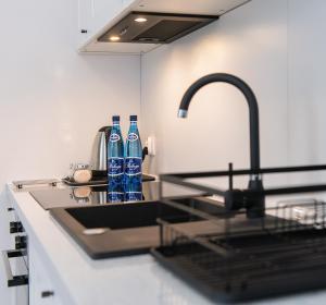 a kitchen with two bottles of water on a sink at Apartamenty Centrum II in Bydgoszcz