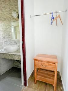 a bathroom with a sink and a wooden table at Hospedaje Las Uvas in Las Uvas +24 photos