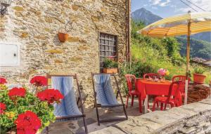 a patio with a table and chairs and an umbrella at Casa poggio delle farfalle in Stazzema