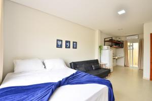 um quarto com uma cama grande e um sofá em InHome - Estúdio 02, conforto e aconchego no Campeche N1518 em Florianópolis