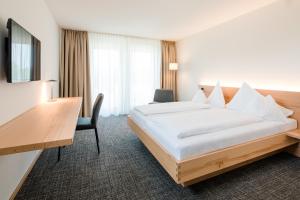a hotel room with a bed and a desk at Hotel Krone in Dornbirn +29 photos