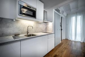 una cucina bianca con lavandino e forno a microonde di JCL first apt in the hearth of Florence a Firenze Altre 21 foto
