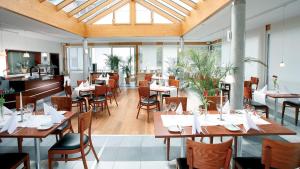 Züfle Hotel Restaurant Spa في سولز أنا نيكار: مطعم فيه طاولات وكراسي في الغرفة
