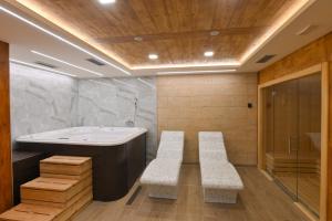 a bathroom with a tub and two benches in it at Apartman Tea - Zlatibor in Zlatibor +42 photos