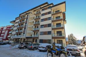a man on a snow bike in front of a building at Apartman Tea - Zlatibor in Zlatibor