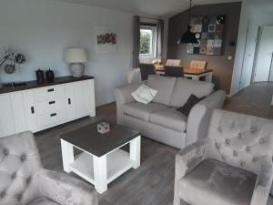 ein Wohnzimmer mit einem Sofa, 2 Stühlen und einem Tisch in der Unterkunft Watervriend in Earnewâld
