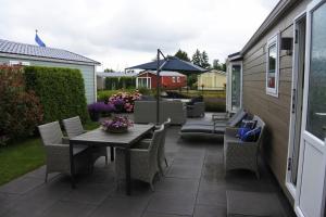 Un patio con una mesa y sillas de madera. en Watervriend, en Earnewâld