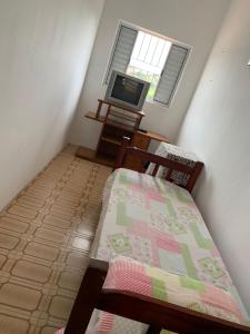 Habitación pequeña con cama y TV. en Casa de hospedagem providências, en Cachoeira Paulista