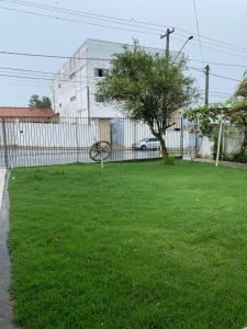 un patio verde con una valla y un árbol en Casa de hospedagem providências, en Cachoeira Paulista