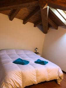 Un dormitorio con una cama con toallas azules. en Villa Natale, en Sestola