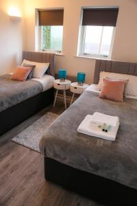 a bedroom with two beds and two tables at Blue Apartment, 2 Bedroom with Balcony, Netflix in Peterborough